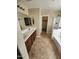Spacious bathroom with double sinks, tile floors, glass-enclosed shower, and walk-in closet at 32071 N Chestnut Trl, San Tan Valley, AZ 85143