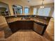 A kitchen island features a granite countertop, stainless steel sink and appliances, and dark wood cabinets at 32071 N Chestnut Trl, San Tan Valley, AZ 85143