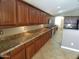 Spacious kitchen featuring granite countertops and wooden cabinets, seamlessly combining style and functionality at 32071 N Chestnut Trl, San Tan Valley, AZ 85143