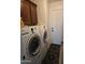 Functional laundry room features front loading Samsung washer and dryer and upper cabinets for storage at 32071 N Chestnut Trl, San Tan Valley, AZ 85143
