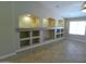 Bright living room featuring custom wall shelving with recessed lighting and ceramic tile flooring at 32071 N Chestnut Trl, San Tan Valley, AZ 85143