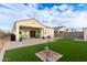 Large backyard featuring artificial turf, a covered patio, and unique water feature at 3530 N 310Th Dr, Buckeye, AZ 85396