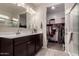 Bright bathroom featuring dual sinks, large mirror, and walk-in closet access at 3530 N 310Th Dr, Buckeye, AZ 85396