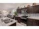 Stylish kitchen featuring stainless steel appliances, granite countertops, and dark wood cabinets at 3530 N 310Th Dr, Buckeye, AZ 85396