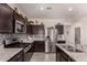 Beautiful kitchen featuring stainless steel appliances, dark wood cabinets, and granite countertops at 3530 N 310Th Dr, Buckeye, AZ 85396