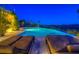 Outdoor swimming pool and lounge chairs at twilight with city lights in the background at 36879 N 38Th St, Cave Creek, AZ 85331