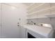 Functional laundry room with shelving above a modern washer and dryer set and convenient access to an exterior door at 3829 W Folley St, Chandler, AZ 85226