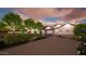 View of a home's exterior, front yard with landscaping, mature trees, and a covered patio at dusk at 3933 E Rancho Dr, Paradise Valley, AZ 85253