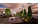 View of a home's exterior, front yard with landscaping, mature trees, and pavers at dusk at 3933 E Rancho Dr, Paradise Valley, AZ 85253
