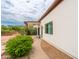 Side view of a home exterior with a covered patio, walkway, and minimalist landscaping at 3933 E Rancho Dr, Paradise Valley, AZ 85253