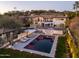 Aerial view of a well-lit property featuring a pool, spa, desert landscaping, and a mountain backdrop at 3977 E Paradise View Dr, Paradise Valley, AZ 85253