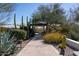 Outdoor walkway leading to a covered sitting area surrounded by lush desert landscaping at 3977 E Paradise View Dr, Paradise Valley, AZ 85253