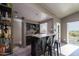 Stylish bar area with granite countertop, black cabinets, barstools, tile backsplash, and lots of natural light at 3977 E Paradise View Dr, Paradise Valley, AZ 85253