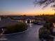 Luxury home boasts lush landscaping, circular driveway, and picturesque city and mountain views at 3977 E Paradise View Dr, Paradise Valley, AZ 85253