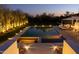 Backyard pool and spa lit up at dusk, with lounge chairs and manicured landscaping at 3977 E Paradise View Dr, Paradise Valley, AZ 85253