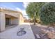 Home's landscaped backyard features a fire pit, mature trees, and desert foliage at 43639 W Blazen Trl, Maricopa, AZ 85138