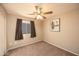 This bedroom features carpet, ceiling fan, and a window at 43639 W Blazen Trl, Maricopa, AZ 85138