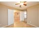Bedroom with ceiling fan, tile floors, view to a living room and double doors at 43639 W Blazen Trl, Maricopa, AZ 85138