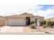 Beige single-story home with a brick-lined driveway and well-maintained landscaping at 43639 W Blazen Trl, Maricopa, AZ 85138