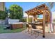Beautiful backyard with a hot tub, covered outdoor kitchen, and a built-in TV for entertainment at 4502 E Hartford Ave, Phoenix, AZ 85032