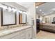 Bathroom with dual vanity, granite countertops, and direct access to main bedroom at 4502 E Hartford Ave, Phoenix, AZ 85032