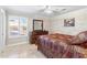 Comfortable bedroom featuring plantation shutters, tile floors, a ceiling fan, and ample natural light at 4502 E Hartford Ave, Phoenix, AZ 85032