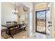 Welcoming foyer showcasing an ornate iron security door, dining room, and neutral tile flooring at 4502 E Hartford Ave, Phoenix, AZ 85032