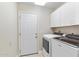 Convenient laundry room with washer, dryer, utility sink, cabinets, and access door at 4502 E Hartford Ave, Phoenix, AZ 85032