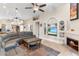 Spacious living room with a fireplace, custom built-ins, a ceiling fan, and seamless flow to the kitchen at 4502 E Hartford Ave, Phoenix, AZ 85032