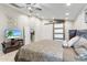 Comfortable main bedroom with a sliding barn door, ceiling fan, tile floors, and ample natural light at 4502 E Hartford Ave, Phoenix, AZ 85032