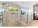 Modern shower with glass enclosure, marble tile, built-in bench, and window for natural light at 4502 E Hartford Ave, Phoenix, AZ 85032