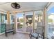 Relaxing sun room leading to the backyard, featuring tile floor, curtains, and large windows at 4502 E Hartford Ave, Phoenix, AZ 85032