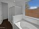 Elegant bathroom with a separate shower and a soaking tub under a window with natural light at 4806 N 186Th Ln, Goodyear, AZ 85395