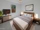 Cozy main bedroom showcases a stylish bed frame, soft lighting, and a decorative wall art piece at 4806 N 186Th Ln, Goodyear, AZ 85395