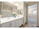 Well-lit bathroom with dual vanities, a large mirror, and a walk-in shower with glass enclosure at 5628 S Winchester --, Mesa, AZ 85212