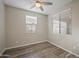 Bright bedroom with wood-look floors, neutral walls, and a ceiling fan, illuminated by natural light through large windows at 5628 S Winchester --, Mesa, AZ 85212