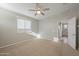 Cozy carpeted bedroom with ceiling fan, closet, and a large window for natural light at 5628 S Winchester --, Mesa, AZ 85212
