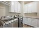 Efficient laundry room featuring modern appliances, white cabinetry, and ample counter space for convenient chores at 5628 S Winchester --, Mesa, AZ 85212