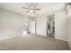 Neutral bedroom with carpeted floors, ceiling fan, and doorway to the en-suite bathroom and closet at 5628 S Winchester --, Mesa, AZ 85212