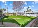 Spacious backyard with lush green lawn, mature trees, putting green and sand trap at 623 E Winter Drive Dr, Phoenix, AZ 85020