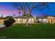 Well-maintained backyard featuring a spacious lawn, mature tree, and covered patio perfect for outdoor activities at 623 E Winter Drive Dr, Phoenix, AZ 85020