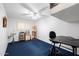 Versatile flex space with a large desk and an easel, featuring dark blue carpet and plenty of natural light at 623 E Winter Drive Dr, Phoenix, AZ 85020