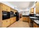 Bright kitchen featuring wood cabinets, black appliances, and laminate flooring at 623 E Winter Drive Dr, Phoenix, AZ 85020