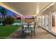 Covered patio with ample seating for outdoor dining overlooking the lush backyard and pool at 623 E Winter Drive Dr, Phoenix, AZ 85020