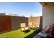 Cozy covered patio with comfortable seating, artificial turf, and modern privacy fence at 6858 E Orion Dr, Scottsdale, AZ 85257