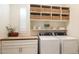 Bright laundry room with built-in shelving, stylish baskets, butcher block countertop, and modern machines at 6858 E Orion Dr, Scottsdale, AZ 85257