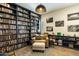 Inviting library featuring floor-to-ceiling bookshelves, comfortable armchair, and ample natural light at 6858 E Orion Dr, Scottsdale, AZ 85257