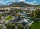 Aerial view of the luxurious home with a resort-style pool and an outdoor kitchen amid lush green lawns at 7014 E Palo Verde Ln, Paradise Valley, AZ 85253