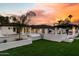 Lush backyard featuring a modern patio design, outdoor kitchen, and elegant landscaping at sunset at 7014 E Palo Verde Ln, Paradise Valley, AZ 85253