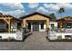 Stunning home entrance with a striking wooden gable and an inviting brick pathway to the custom double doors at 7014 E Palo Verde Ln, Paradise Valley, AZ 85253